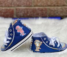 a pair of children's blue shoes with cartoon characters on them sitting on white fur