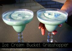 two glasses filled with ice cream on top of a table next to a person's hand