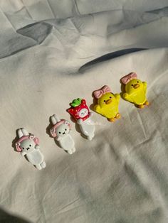 five small plastic animals sitting on top of a white sheet