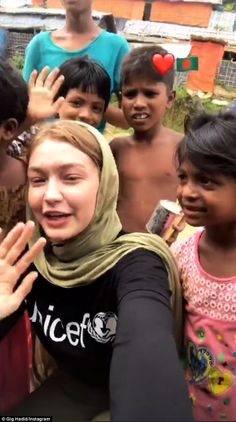 a group of young children standing next to each other with their hands in the air