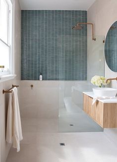 a bathroom with a sink, mirror and bathtub next to a window in it