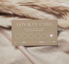 a card sitting on top of a bed next to a fur covered comforter and pillow