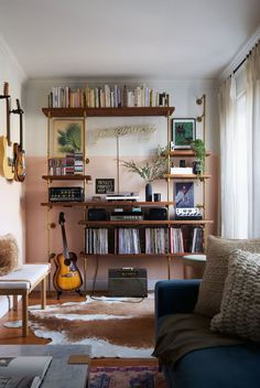 a living room filled with lots of furniture and bookshelves covered in musical instruments