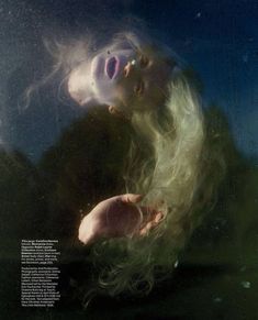 a woman is floating in the water with her hair blowing