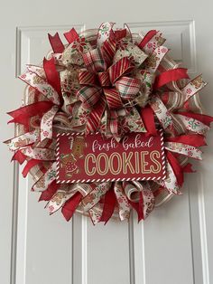 a wreath that says fresh baked cookies hanging on a door with ribbon around the edges