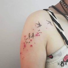 a woman's shoulder with birds and flowers on it