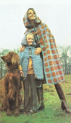 a woman and two children standing next to each other in front of a brown dog