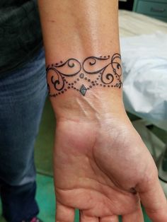 a woman's hand with a tattoo on the wrist and an intricate design in the middle