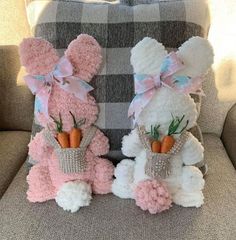 two stuffed animals sitting on top of a couch next to each other with carrots sticking out of their mouths