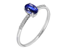 an oval blue sapphire and diamond ring with white diamonds on the sides, set in 18k white gold