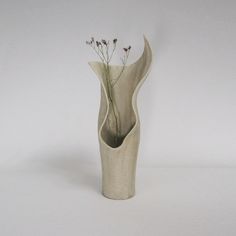 a white vase with some flowers in it