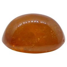 an orange stone sitting on top of a white surface