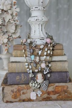 a stack of books sitting on top of each other next to a vase filled with flowers