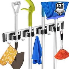 three brooms and two cleaning brushes hanging on a rack