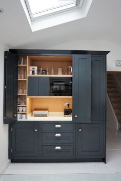 a kitchen with an open cabinet and skylight