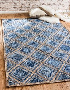 a blue area rug on the floor in front of a brick wall and wooden floors