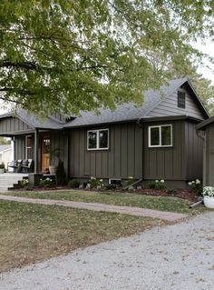 a brown house with white trim on the front and side windows is shown in this photo