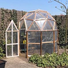 a small greenhouse in the middle of a garden