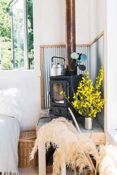 a room with a stove and some flowers