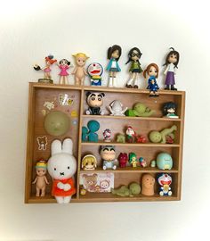 a wooden shelf filled with lots of toy figurines on top of it's sides