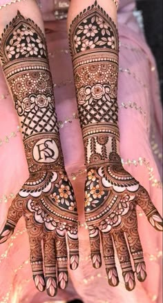 two hands with henna tattoos on them