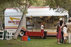 people are standing in front of a food truck