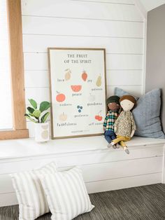 a stuffed animal sitting on top of a window sill next to a framed poster