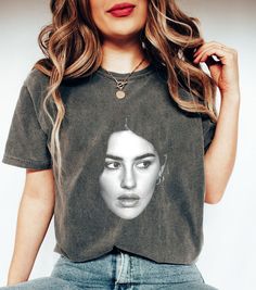 a woman with long hair wearing a t - shirt that has an image of her face on it