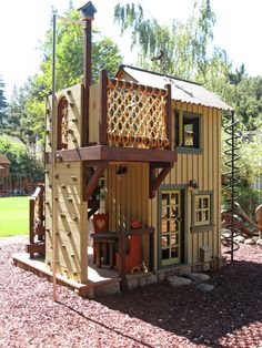 a small wooden structure with a play set in the background