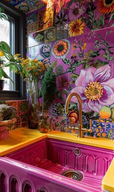 a kitchen with colorful wallpaper and sink in front of a window filled with potted plants