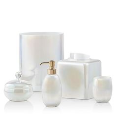 white bathroom accessories including soap dispenser, toothbrush holder and glass container