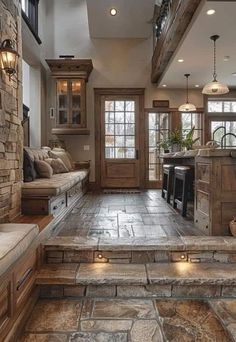 a kitchen with stone flooring and stairs leading up to it