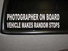 a sign that says photographer on board vehicle makes random stops in front of the camera