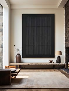 a living room with a couch, coffee table and large black painting on the wall