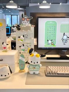 hello kitty figurines are on display in front of a computer monitor and keyboard