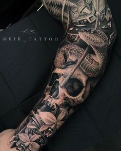 a man's arm with a skull and flowers on it