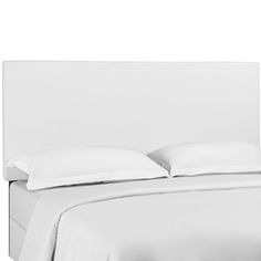 a bed with white linens and pillows on top of the headboard is shown