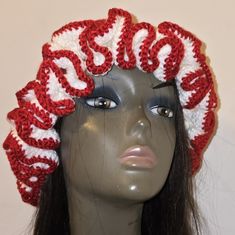 a mannequin head wearing a red and white crocheted hat with braids