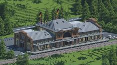 an aerial view of a train station in the middle of some trees and grass,