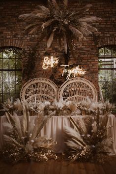 a table topped with lots of white flowers and palm trees next to a brick wall