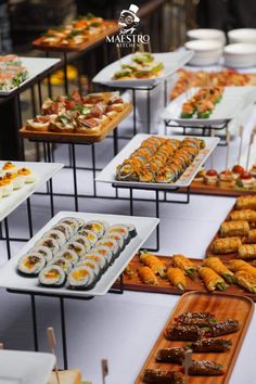 an assortment of sushi and other food items are on display at a buffet table