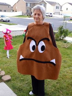 an older woman is holding a large bag with a frowning face on it while standing in the grass