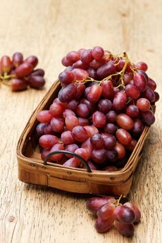 grapes in a basket on a wooden table