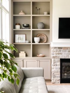 a living room filled with furniture and a flat screen tv mounted on a wall above a fire place