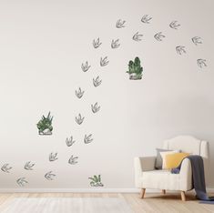 a living room with a white couch and wall decals in the shape of plants