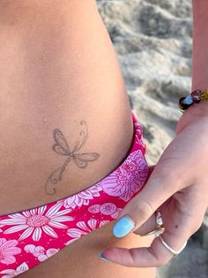 a close up of a person's stomach with a dragonfly tattoo on it