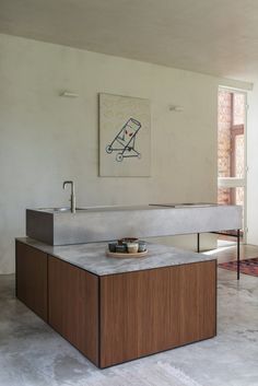 a kitchen counter with a bowl on it in front of a painting hanging above the sink