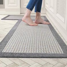 a woman standing on top of a gray rug