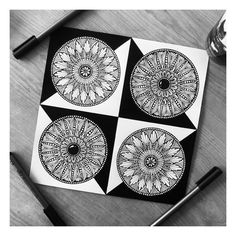 four black and white designs on a piece of paper next to some pens, pencils and an ink pen