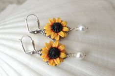 Featuring Hand sculpted Red Yellow Sunflower Earrings. Perfect for Sunflower wedding theme, or sunflower jewelry collection. All Sunflower collection: https://www.etsy.com/shop/MorningHeirloom?ref=seller-platform-mcnav&search_query=sunflower Details: - Sunflower Flower size is approximately 17-18mm. - Glued on Filigree. - 6mm white Swarovski Pearls . Cream available. - The entire length is approximately 4cm. - Metal Finish available in Silver Plated, Gold plated, antiqued brass and Rose Gold Elegant Sunflower Design Flower Earrings For Gift, White Flower Jewelry With Sunflower Design, White Sunflower Design Flower Jewelry, Wedding Jewelry With Sunflower Design, Elegant Sunflower Design Flower Earrings, Yellow Sunflower Design Earrings For Gift, Yellow Sunflower Design Earrings Gift, Sunflower Wedding Theme, Yellow Sunflower Design Dangle Jewelry